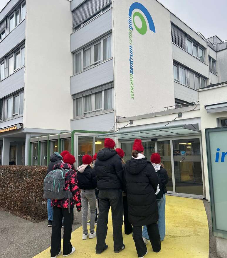 Die jungen Menschen besuchen Seniorinnen und Senioren im Altersheim. 