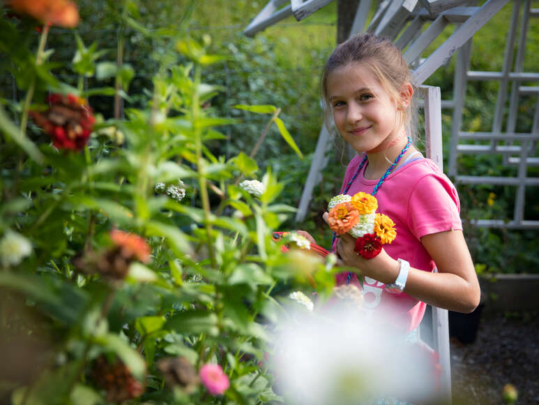 Kind im Garten mit Blumen