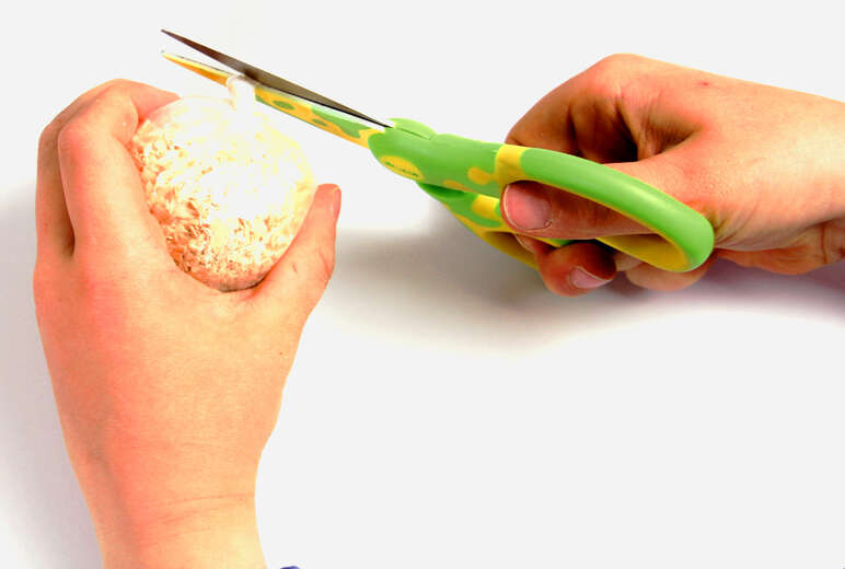 Mische zwei Kinderhände voll Sägemehl mit wenig Sand, fülle das Gemisch in den Plastikbeutel und knüpfe ihn satt zu. Schndeide den Plastikrest über dem Knoten ab.